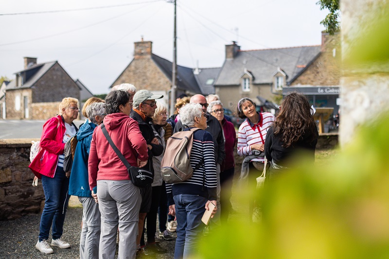 Un groupe écoute le guide pendant la balade patrimoine.